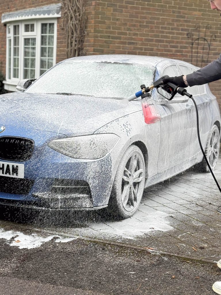 Mobile car detailing service applying foam pre-wash to a BMW car at Studio Detailing in West Sussex, Pound Hill